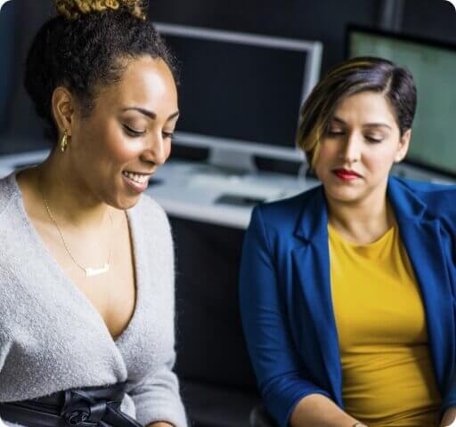 Women looking at something & talking about it